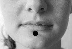CV24 (Conception Vessel 24) acupressure point located under the lower lip on a female face